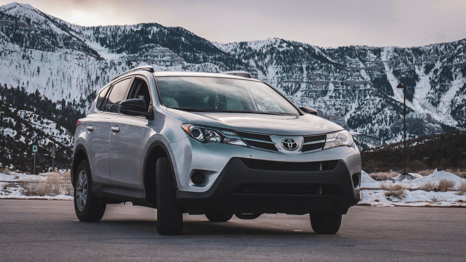 Silver SUV with snowy mountains behind
